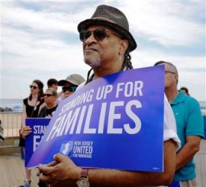 Gary Paul Wright holds a sign Wednesday, July 24, 2013, as he stands with others during a large gathering on the boardwalk in Asbury Park, N.J., as the New Jersey United for Marriage campaign announced that several national groups that support recognizing same-sex marriage are teaming up in New Jersey, saying that the state is primed to allow gay couples to wed. (AP Photo/Mel Evans)